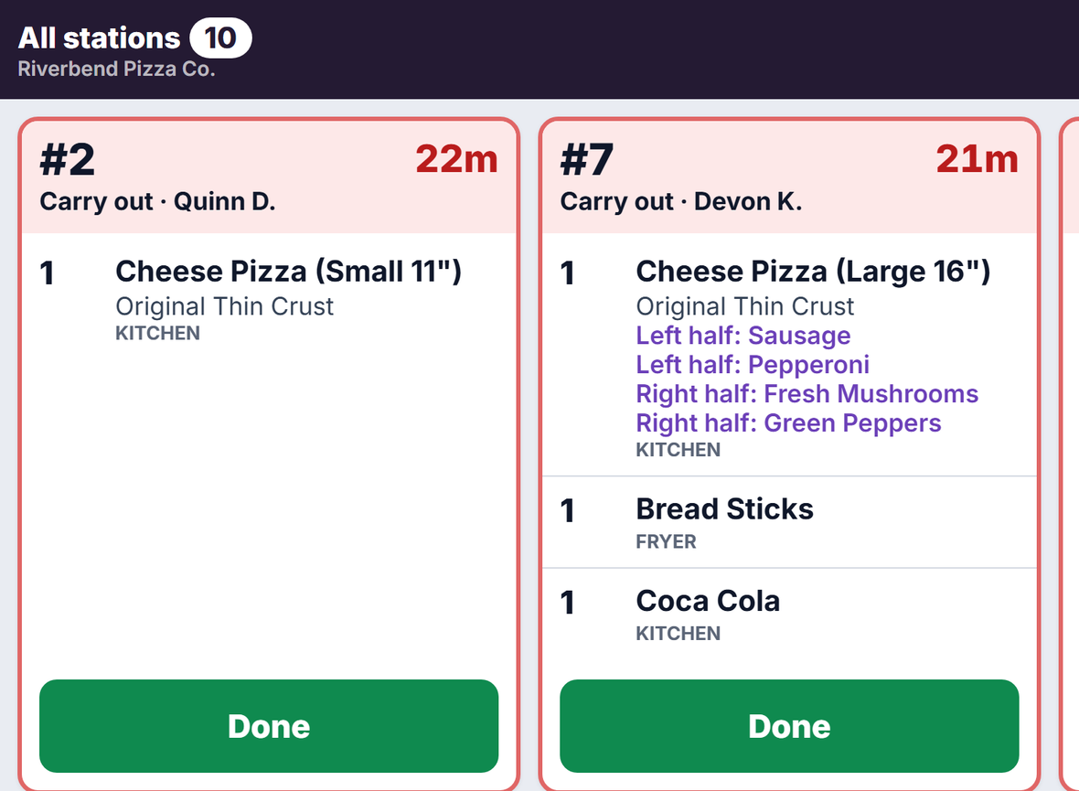 The kitchen screen showing all stations: two tickets side by side with wait timers of 22 and 21 minutes, each line tagged KITCHEN or FRYER, and a Done button on each.